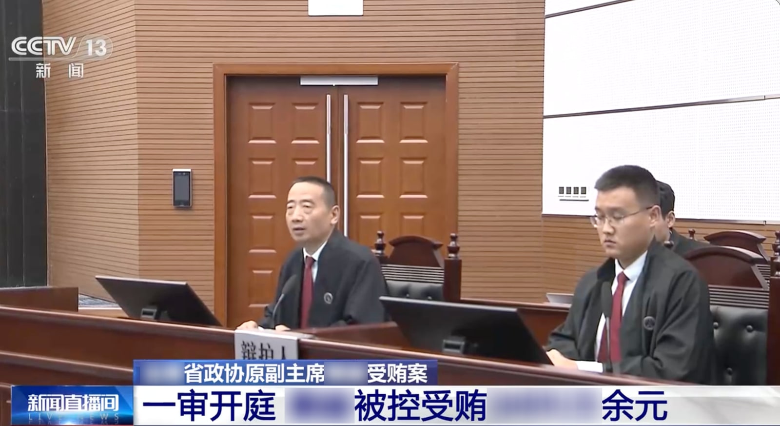 央视报道的庭审现场，部分字幕已作模糊处理